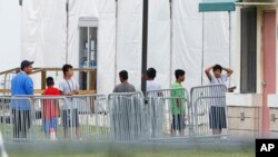 FILE - Immigrant children walk in a line outside the Homestead Temporary Shelter for Unaccompanied Children, a former Job Corps site that now houses them in Homestead, Fla., June 20, 2018.