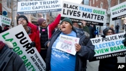 Manifestantes marchan en la calle cerca de un puesto de control de seguridad para ingresar a la ceremonia de asunción de Donald Trump en Washington.