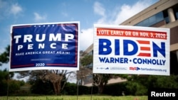 FILE - Yard signs supporting U.S. President Donald Trump and Democratic U.S. presidential nominee and former Vice President Joe Biden are seen outside of an early voting site at the Fairfax County Government Center in Virginia, Sept. 18, 2020.