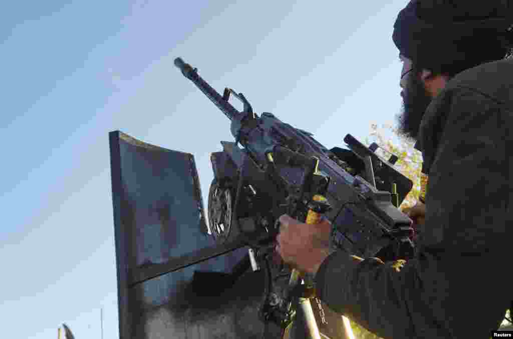 A Free Syrian Army fighter aims his weapon towards a Syrian military warplane (not pictured) in Aleppo's al-Amereya district December 12, 2012. Picture taken December 12, 2012. REUTERS/Saleh Anadani (SYRIA - Tags: CONFLICT MILITARY)