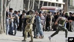Tentara NATO mengamankan lokasi setelah terjadinya serangan oleh militan Taliban di Kabul hari Minggu (15/4).