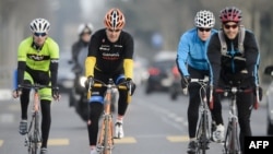 FILE - In this picture taken on March 16, 2015 US Secretary of State John Kerry (2-L) rides his bike during a break in Lausanne. 