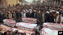 People attend funeral prayers for the victims of Friday's suicide bombing in Peshawar, Pakistan, March 5, 2022.