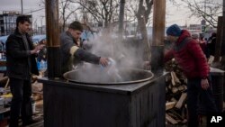 Ukrainian volunteers prepare food for displaced people outside Lviv railway station, in Lviv, western Ukraine, March 3, 2022.