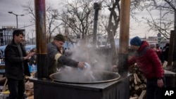 Voluntarios ucranianos preparan comida para personas desplazadas fuera de la estación de tren de Lviv, Ucrania, el 3 de marzo de 2022.