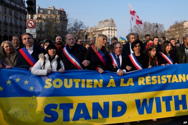 La alcaldesa de París y candidata presidencial socialista Anne Hidalgo, a la derecha, camina con políticos que sostienen una pancarta que dice "Apoya a Ucrania" durante una marcha contra la invasión rusa de Ucrania, en París, el 5 de marzo de 2022.