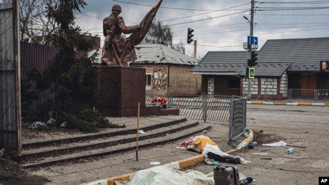 The dead bodies of people killed by Russian shelling lay covered in the street in the town of Irpin, Ukraine, March 6, 2022.