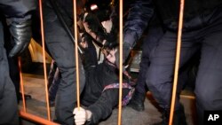 Police detain a demonstrator during an action against Russia's attack on Ukraine in St. Petersburg, Russia, Saturday, Feb. 26, 2022. Protests against the Russian invasion of Ukraine resumed on Saturday evening, with people taking to the streets of Moscow and St. Petersburg for the third straight day despite mass arrests. OVD-Info rights group reported that at least 325 people were detained in 26 Russian cities on Saturday in antiwar protests, nearly half of them in Moscow.(AP Photo/Dmitri Lovetsky)