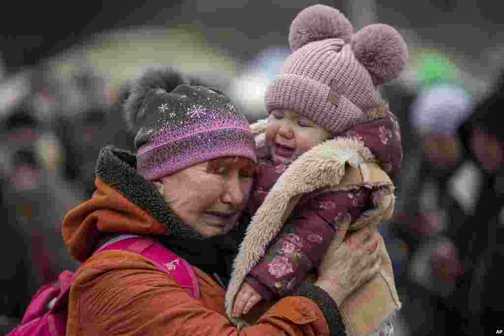 A woman holding a child cries after fleeing from the Ukraine and arriving at the border crossing in Medyka, Poland, March 7, 2022. 