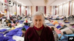 Nellya Nahorna, 85 years-old, who fled the Russian invasion from Zaporizhzhia with her daughter Olena Yefanova, poses for a portrait inside a ballroom converted into a makeshift refugee shelter at a 4-star hotel & spa, in Suceava, Romania, Friday, March 4, 2022. (AP Photo/Andreea Alexandru)