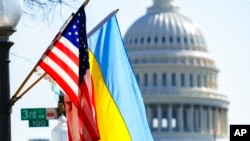 FILE - The flags of Ukraine, the United States, and the District of Columbia fly together on Pennsylvania Avenue near the Capitol, March 5, 2022, by order of the mayor of Washington. 
