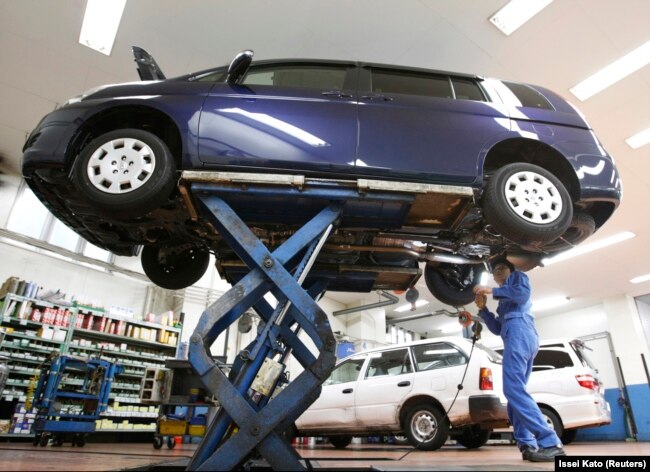Seorang pekerja sedang melakukan pengecekan sebuah mobil di toko dealer mobil di Tokyo 1 November 2010. (Foto: Reuters/Issei Kato)