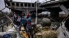 Pengungsi menyeberangi jembatan yang hancur saat mereka melarikan diri dari kota Irpin, barat laut Kyiv, 7 Maret 2022. (Dimitar DILKOFF / AFP)