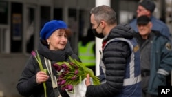 Giới chức Romania tặng hoa cho một phụ nữ Ukraine tị nạn sau khi bà đã ra được khỏi biên giới vào ngày Quốc tế Phụ nữ 8/3/2022. 