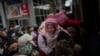 Orang-orang berjuang untuk naik kereta api ke Lviv di stasiun Kyiv, Ukraina, sambil menggendong anak-anak mereka, Senin, 7 Maret 2022. Rusia membuka beberapa koridor kemanusiaan untuk memungkinkan warga sipil melarikan diri dari Ukraina. (Foto AP/Emilio Morenatti)