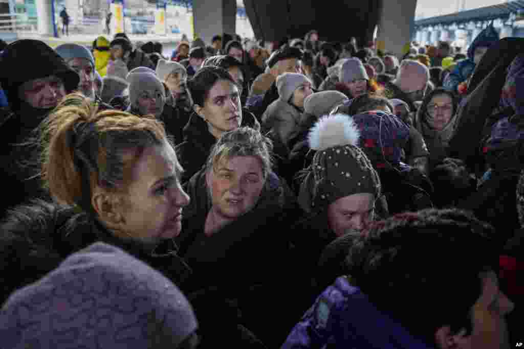 Una mujer se desmaya mientras la gente se aglomera para intentar entrar en un tren a Lviv en la estación de Kiev, Ucrania.