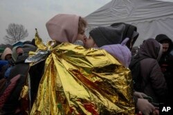A woman kisses a child after fleeing from the Ukraine and arriving at the border crossing in Medyka, Poland, March 7, 2022.