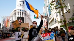 Protesters shout slogans and carry flags and banners during a march denouncing Russia's invasion on Ukraine, in Tokyo, March 5, 2022.