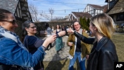 Newlywed Maria toasts with friends during her wedding ceremony at a home, March 5, 2022, in Oak Park, Ill.