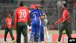 আফগানিস্তানের হজরতুল্লাহ জাজাই ঢাকার শের-ই-বাংলা জাতীয় ক্রিকেট স্টেডিয়ামে বাংলাদেশ ও আফগানিস্তানের মধ্যে দ্বিতীয় টি-টোয়েন্টি আন্তর্জাতিক ক্রিকেট ম্যাচ জয়ের পর তার সতীর্থ দরবেশ রাসুলিকে আলিঙ্গন করছেন। ৫ মার্চ ২০২২। 
