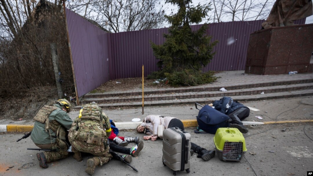 Ukrajinski vojnici pomažu povređenima u ukrajinskom gradu Irpin (Foto: AP)
