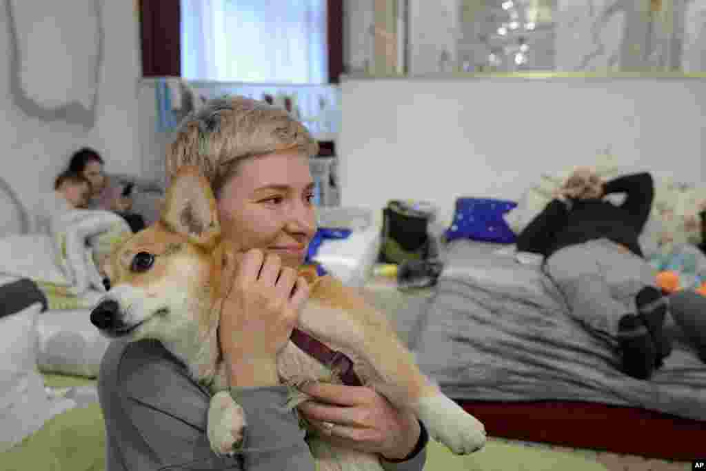 Olga Okhrimenko, quien huyó de la invasión rusa de Kharkiv el 1 de marzo, sostiene a su perro Knolly mientras se sientan dentro de un salón de baile convertido en un refugio improvisado para refugiados, en Suceava, Rumania, el 4 de marzo de 2022.