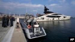 Italian Finance Police stand by the yacht "Lady M," owned by Russian oligarch Alexei Mordashov, docked at Imperia's harbor, Italy, March 5, 2022.