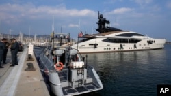 Italian Finance Police stand by the yacht "Lady M," owned by Russian oligarch Alexei Mordashov, docked at Imperia's harbor, Italy, March 5, 2022.