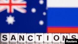 Plastic letters arranged to read 'Sanctions' are placed in front the flag colors of Australia and Russia in this illustration taken Feb. 28, 2022. (Reuters/Dado Ruvic/Illustration)