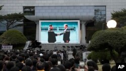 FIlE - in this April 27, 2018, file photo, a large screen shows an image of South Korean President Moon Jae-in, right, and North Korean leader Kim Jong Un during a ceremony to mark the first anniversary of Panmunjom declaration held outside of the Peace House at the southern side of Panmunjom in the Demilitarized Zone, South Korea. (AP Photo/Lee Jin-man, Pool)