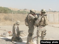 Matthew Parker, al centro con rifle, instruye a otros soldados estadounidenses sobre el uso del rifle de asalto AK-47 durante su servicio militar en Tikrit, Irak, en 2006. [Cortesía: Matthew Parker]