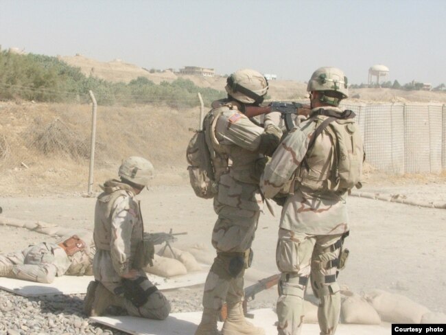 Matthew Parker, al centro con rifle, instruye a otros soldados estadounidenses sobre el uso del rifle de asalto AK-47 durante su servicio militar en Tikrit, Irak, en 2006. [Cortesía: Matthew Parker]