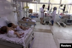 FILE - Doctors work at the maternity ward at the Indira Gandhi hospital in Kabul, Afghanistan, Oct. 24, 2021.