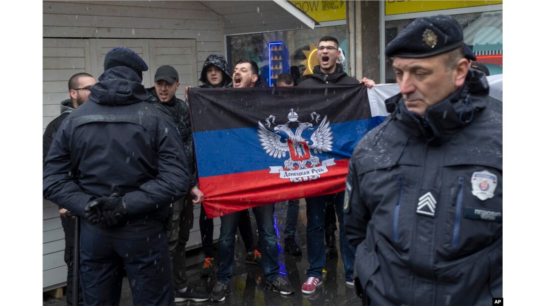 Ljudi drže zastavu otceplene Donjetske Narodne Republike, dok pokušvaju da ometaju protest podrške Ukrajini i protiv ruske invazije, u centru Beograda, Srbija, 6. marta 2022.