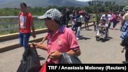 FILE - Venezuelan migrants cross the Simon Bolivar bridge from Venezuela to the Colombian city of Cucuta, May 31, 2018. 
