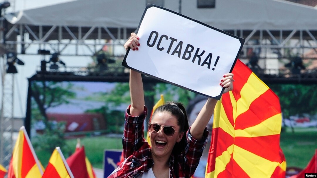 Seorang perempuan mengibarkan poster bertuliskan "mengundurkan diri" dalam demo anti pemerintah di Skopje, Macedonia, 17 Mei 2015. 