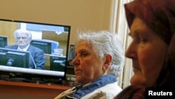 Sajma Smajlovic (R) and Vasva Smajlovic watch on television the genocide trial of former Bosnian Serb leader Radovan Karadzic over the 1995 Srebrenica massacre as he appears before the U.N. tribunal in The Hague, as they gather at Smajlovic's house in Potocari near Srebrenica March 24, 2016. 