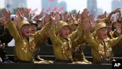 Para tentara veteran Perang Korea melambaikan tangan untuk pemimpin mereka, Kim Jong-un dalam parade militer memperingati 60 tahun berakhirnya perang Korea (27/7).