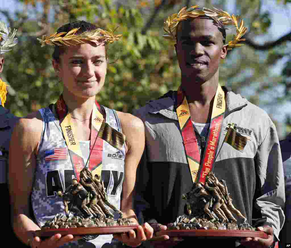First-place female finisher Meghan Curran, left, from Moorestown, N.J., and first-place male finisher Samuel Kosgei, from Junction City, Kan., after the running of the 39th Marine Corps Marathon, in Arlington, Va., Oct. 26, 2014.