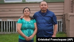 In this photo provided by Cristobal Francisquez, his parents Paulina and Marcos Francisco pose for a photo in front of their house in Sioux City, Iowa, Monday, May 25, 2020.