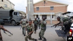 Government military officers run outside the air force base near the airport in Antananarivo, Madagascar, 20 Nov 2010