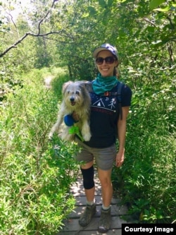 Ashley Thompson of VOA Learning English holds her dog Dublin as they hike trails together in West Virginia. (Photo Courtesy of Ashley Thompson)