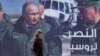 A woman passes a billboard showing Russian President Vladimir Putin in Damascus, Monday, March 7, 2022. The Arabic poster reads "The victory for Russia." (Omar Sanadiki/AP)