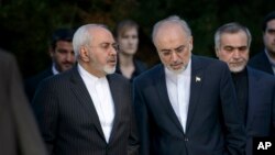 Iranian Foreign Minister Javad Zarif, left, talks with the head of the Iranian Atomic Energy Organization, Ali Akbar Salehi, after an afternoon meeting with U.S. officials in Lausanne, Switzerland, March 27, 2015.