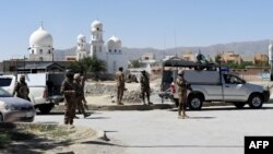 FILE - Pakistani soldiers stand guard at the site where two Chinese missionaries was kidnapped in the neighborhood of Jinnah town in Quetta on May 24, 2017.