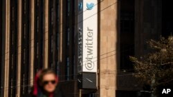 A person passes signage near Twitter's headquarters in San Francisco, California, Nov. 1, 2022.