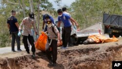 Polisi dan tim penyelamat melakukan penguburan massal korban tewas gempa dan tsunami di Palu.