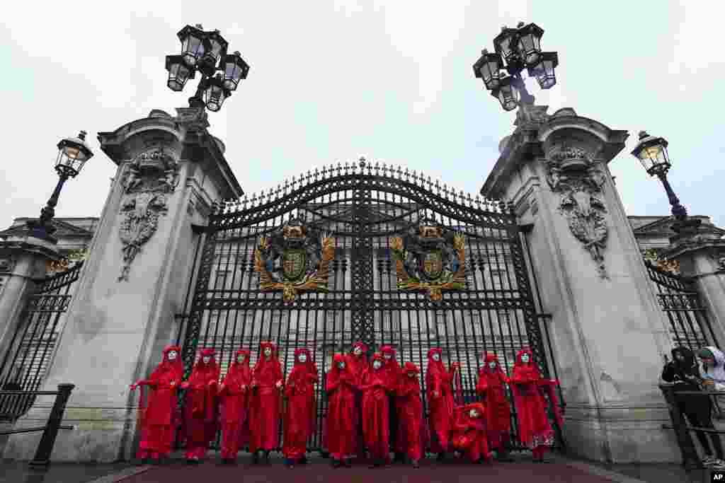 Activistas por el cambio climático posan para los medios de comunicación fuera del Palacio de Buckingham durante una protesta del grupo Rebelión de la Extinción en Londres, el lunes 7 de octubre de 2019. Foto AP / Alberto Pezzali