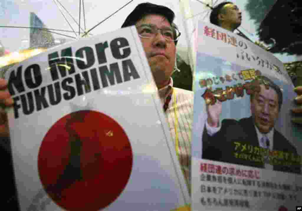 ARCHIV: Ein Demonstrant haelt in Tokyo, Japan, Plakate mit der Aufschrift "No More Fukushima" und einem Portraet des japanischen Premierministers Noda Yoshihiko, um gegen eine erneute Inbetriebnahme des Atomkraftwerkes Ohi zu protestieren (Foto vom 01.07.