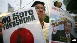 Seorang pengunjuk rasa menyuarakan protes anti PLTN-nya dengan memegang kertas bertuliskan "No More Fukushima" dan sebuah potret PM Jepang Yoshihiko Noda di Tokyo, Sabtu (15/12).